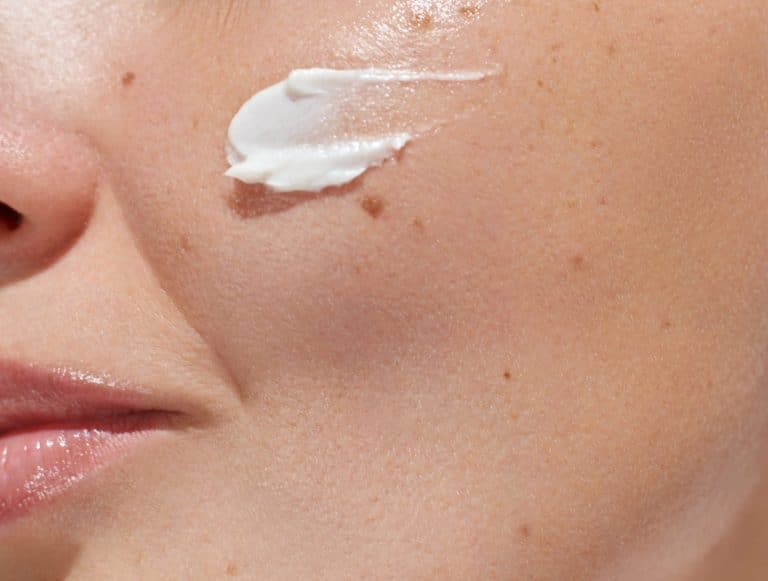 Femme qui applique un produit de soin de la peau pour le visage