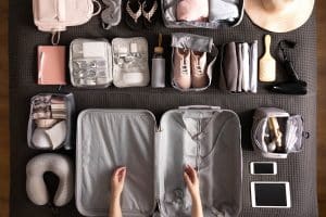 personne qui organise avec des compartiments sa valise pour pour un week-end ou des vacances